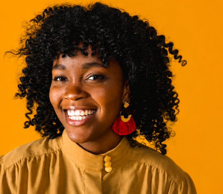 Smiling business owner in front of an orange backdrop